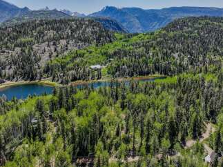 Discover this stunning mountain retreat nestled amidst lush aspen and pine forests, offering breathtaking views of a serene lake and majestic peaks.