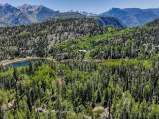 Discover your private mountain retreat nestled amongst lush evergreen and aspen forests, offering breathtaking views of snow-capped peaks.