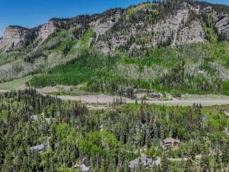 Nestled amidst a lush forest and towering mountains, this property offers a serene escape with multiple charming homes.