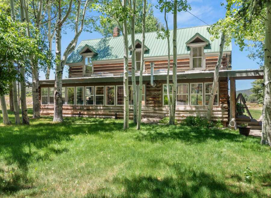 Nestled amongst mature aspen trees, this charming log home offers a serene retreat.