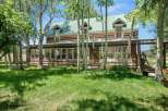 Nestled amongst mature aspen trees, this charming log home offers a serene retreat.