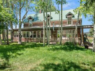 Nestled amongst mature aspen trees, this charming log home offers a serene retreat.