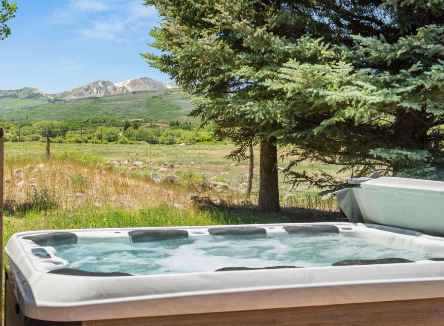 Relax and unwind in this luxurious hot tub, offering breathtaking views of snow-capped mountains and lush green valleys.