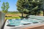 Relax and unwind in this luxurious hot tub, offering stunning views of the surrounding mountains and lush greenery.