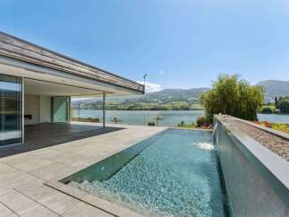 Experience luxury living with this stunning modern home featuring a sleek infinity pool and expansive outdoor living space.