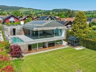 Experience modern luxury in this stunning home featuring a sleek infinity pool and expansive glass walls that seamlessly blend indoor and outdoor living.