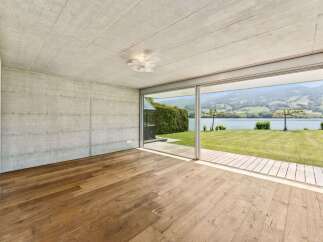 Experience modern living with this stunning property featuring raw concrete walls and a warm, natural wood floor.
