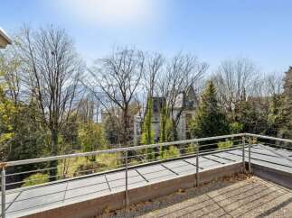 Enjoy the serene views from this property's balcony, overlooking a lush garden and a charming estate.