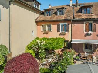 Charming multi-level home with a vibrant garden and outdoor seating area.