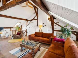 Discover this charming attic living space, featuring exposed wooden beams and a vaulted ceiling that adds rustic character.