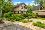 Discover this charming home featuring a light-colored stucco exterior and a durable green roof.