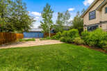 Enjoy the outdoors in this spacious backyard featuring a large flagstone patio perfect for entertaining and a lush green lawn.
