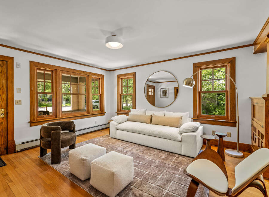 Step into this inviting living room featuring a plush white sofa adorned with accent pillows, perfect for relaxation.