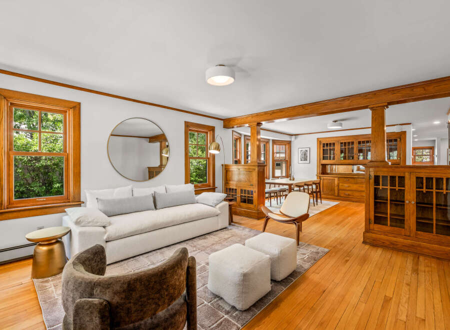 Step into this beautifully appointed living and dining area, featuring rich hardwood floors and elegant wooden built-ins that exude timeless charm.
