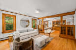 Step into this beautifully appointed living and dining area, featuring rich hardwood floors and elegant wooden built-ins that exude timeless charm.