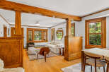 Step into this beautifully appointed living and dining area, featuring rich hardwood floors and stunning natural light pouring in through large wooden-framed windows.