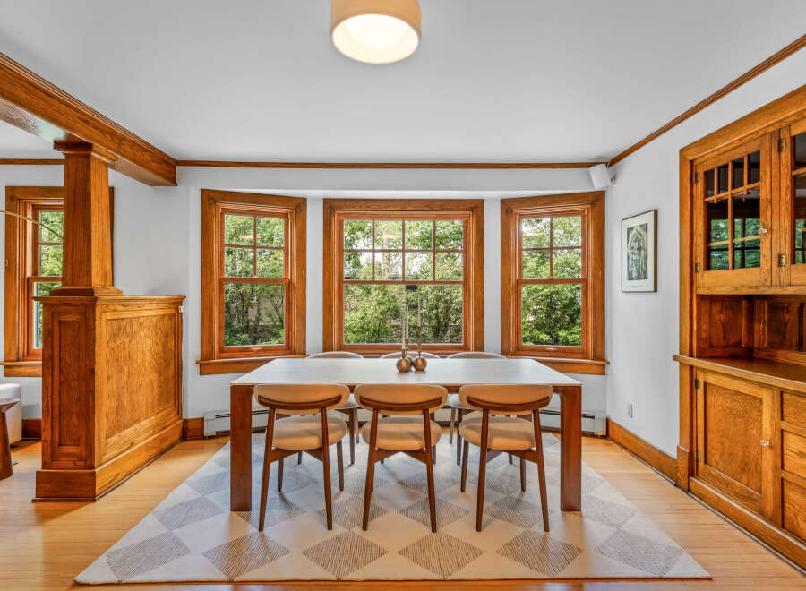 This dining room features beautiful natural wood accents, including wainscoting, trim, and a built-in hutch.
