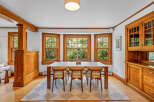 This dining room features beautiful natural wood accents, including wainscoting, trim, and a built-in hutch.