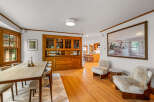 Experience elegant dining in this beautifully appointed space, featuring a large wooden hutch with glass-front cabinets and ample storage.