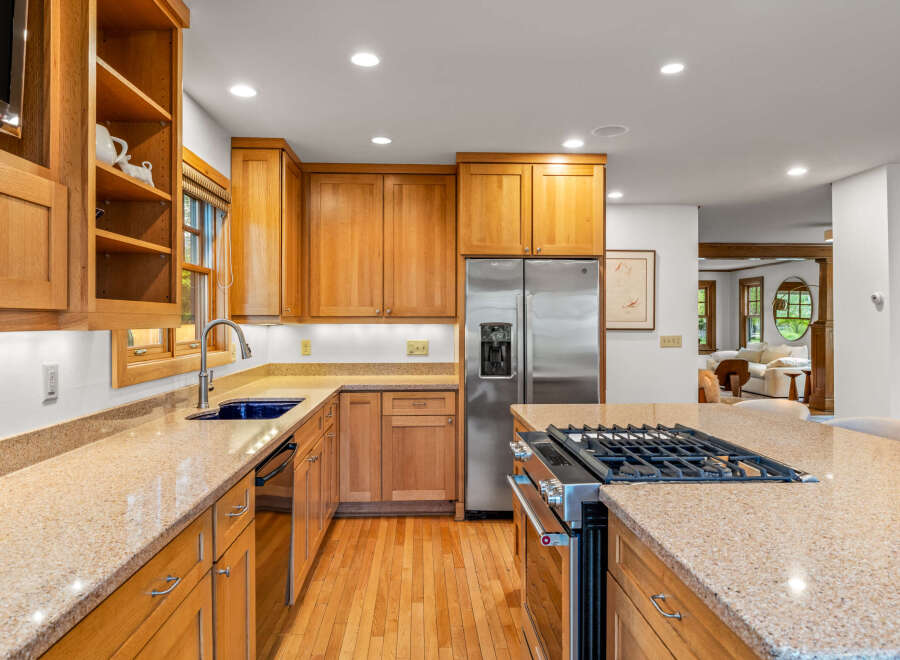 This spacious kitchen features beautiful light oak cabinetry and granite countertops, offering a warm and inviting atmosphere.