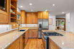 This spacious kitchen features beautiful light oak cabinetry and granite countertops, offering a warm and inviting atmosphere.