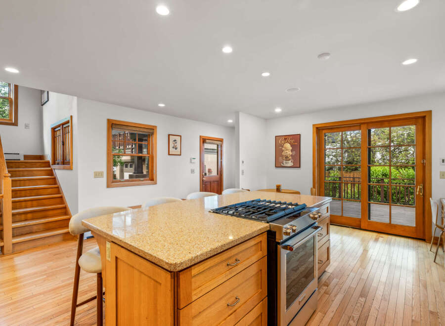 This spacious kitchen boasts a large granite island with a gas range, perfect for culinary enthusiasts.