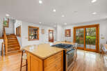 This spacious kitchen boasts a large granite island with a gas range, perfect for culinary enthusiasts.