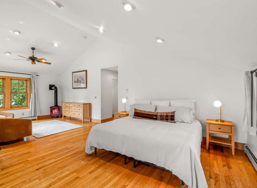 Experience cozy living in this charming bedroom featuring a vaulted ceiling with a ceiling fan and recessed lighting.