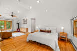 Experience cozy living in this charming bedroom featuring a vaulted ceiling with a ceiling fan and recessed lighting.