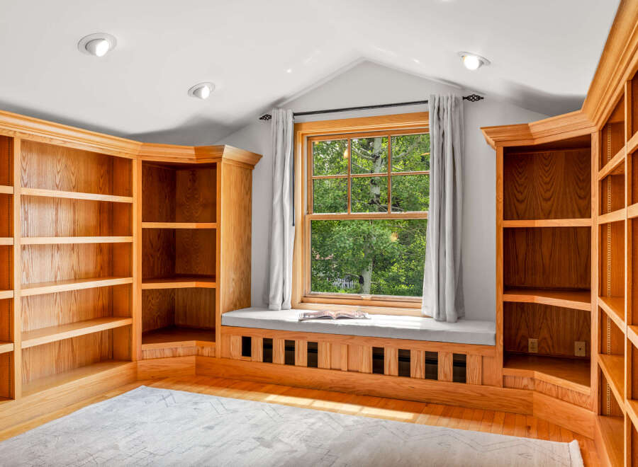This inviting room features custom built-in oak bookshelves that offer ample storage and display space.
