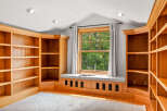 This inviting room features custom built-in oak bookshelves that offer ample storage and display space.