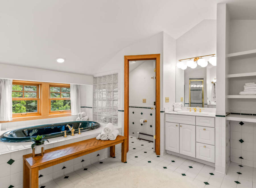 Indulge in luxury in this stunning bathroom featuring a deep soaking tub with elegant brass fixtures, perfect for unwinding.