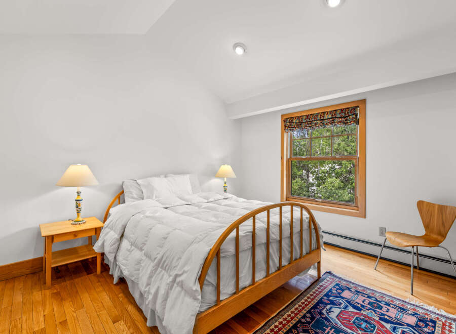 This charming bedroom features a cozy queen-sized bed with crisp white linens, perfect for a restful night's sleep.