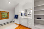 This bright and airy bathroom features a spacious vanity with ample storage and a large mirror, perfect for your morning routine.