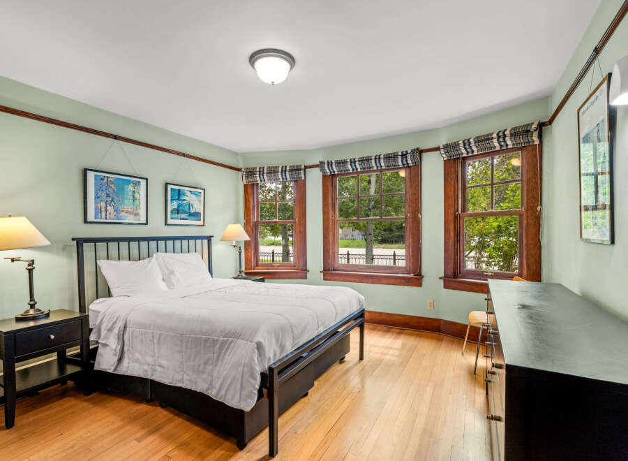 This charming bedroom features a comfortable queen-size bed with crisp white linens, perfect for a restful night's sleep.