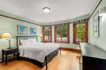 This charming bedroom features a comfortable queen-size bed with crisp white linens, perfect for a restful night's sleep.
