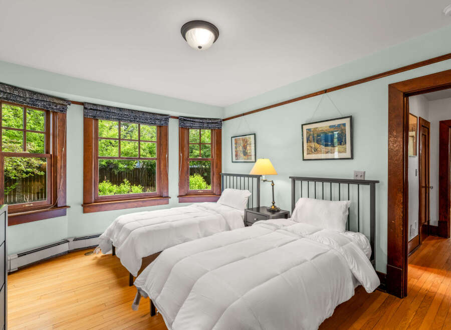 This charming bedroom features two twin beds with crisp white linens, perfect for guests or a shared space.