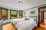 This charming bedroom features two twin beds with crisp white linens, perfect for guests or a shared space.