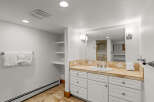 This spacious bathroom features a large vanity with ample storage and a beautiful tiled countertop.