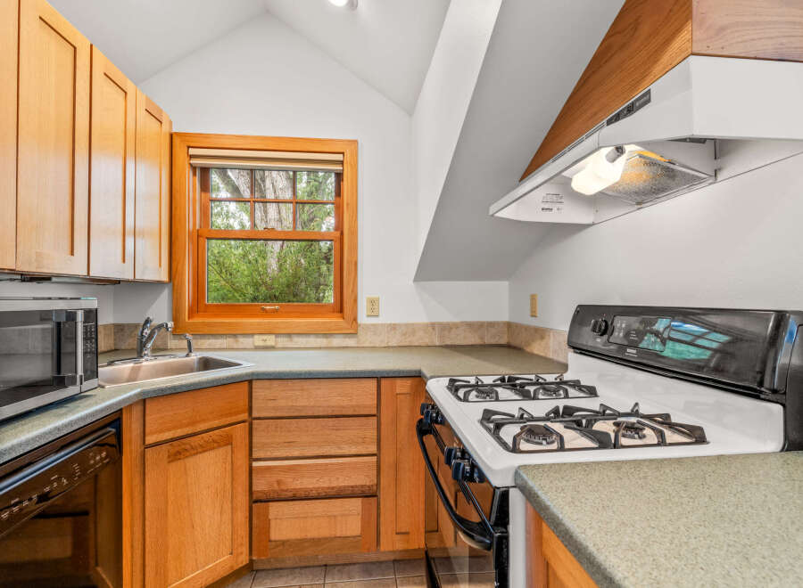 Discover this charming kitchen featuring warm wooden cabinetry and a convenient gas range.
