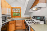 Discover this charming kitchen featuring warm wooden cabinetry and a convenient gas range.