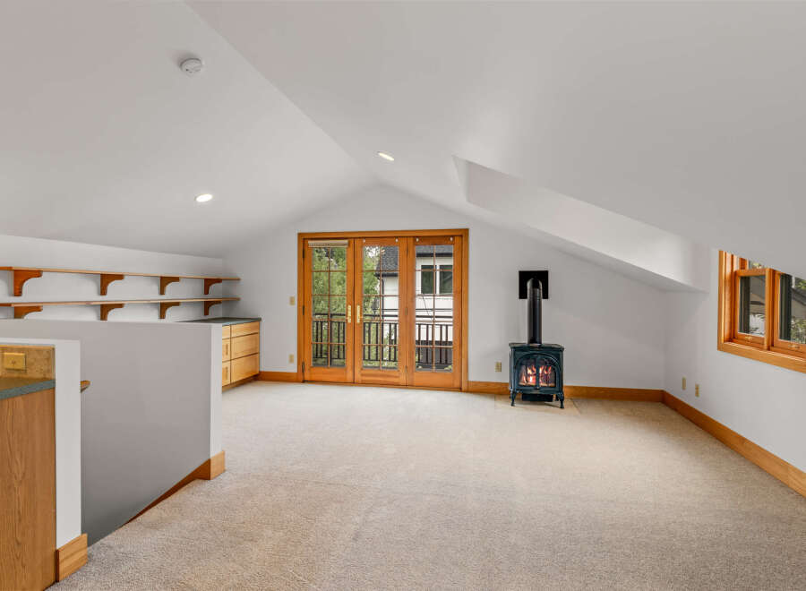 This charming attic space features a cozy wood-burning stove, perfect for chilly evenings.