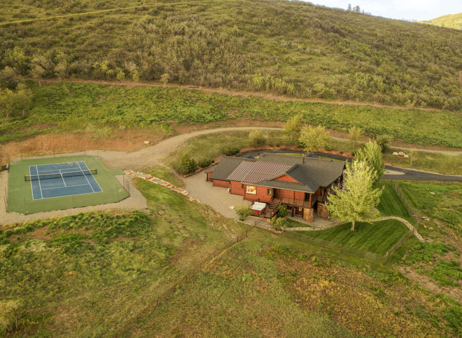 Experience luxury mountain living in this stunning property featuring a spacious home with a private tennis court.