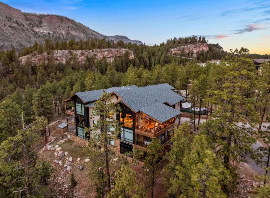 Experience luxury mountain living in this stunning contemporary home, nestled amidst towering pines and dramatic rock formations.