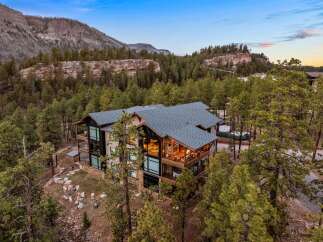 Experience luxury mountain living in this stunning contemporary home, nestled amidst towering pines and dramatic rock formations.