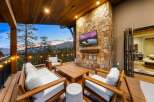 Experience luxury outdoor living with this stunning covered patio, featuring a cozy seating area around a modern fireplace and a large flat-screen TV.