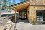 Discover modern mountain living with this stunning home featuring a striking stone facade and a dramatic angled wood-paneled entryway.