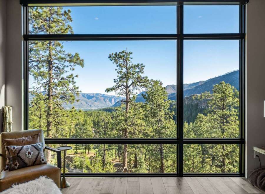 Experience breathtaking panoramic views from this stunning property, featuring expansive floor-to-ceiling windows that frame a majestic mountain landscape.