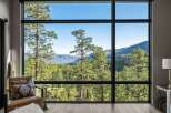 Experience breathtaking panoramic views from this stunning property, featuring expansive floor-to-ceiling windows that frame a majestic mountain landscape.