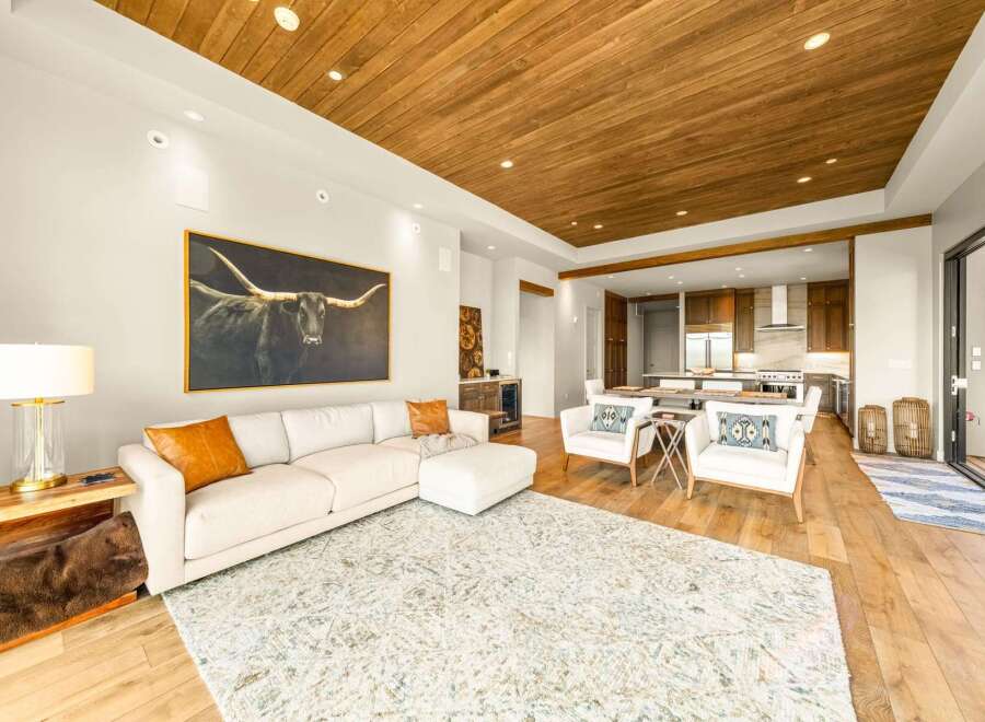 Experience luxurious open-concept living with a stunning longhorn artwork as the centerpiece of this spacious living area.